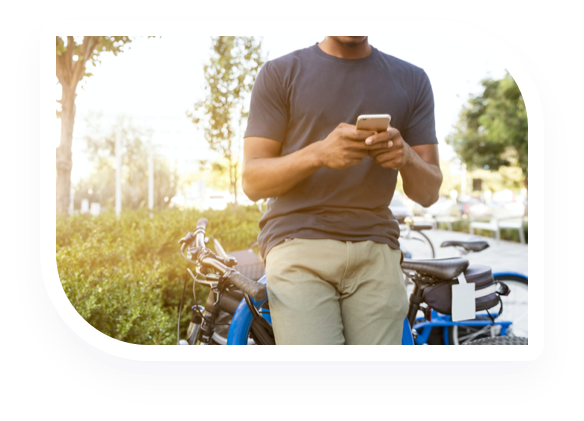 man leaning on bike with phone