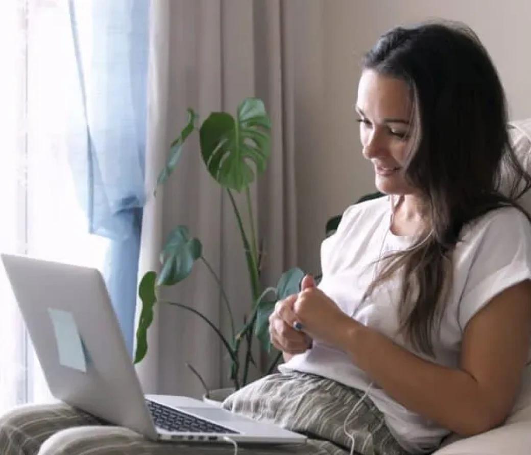 Young woman looking at a laptop and smiling