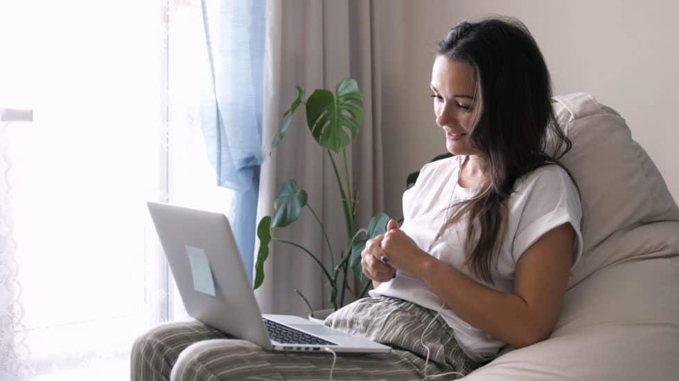 Young woman looking at a laptop and smiling