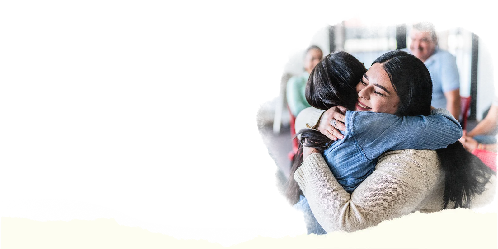 two women in a group counseling session hugging